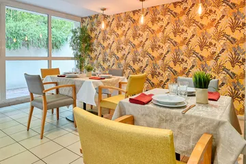 Salle de restaurant orange et jaune baie vitrée vue jardin ehpad à Marseille, Résidence Les Epis d'Or