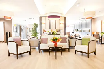 Salon moderne chic grande pièce avec décoration rétro sobre fauteil blanc et lumineuse