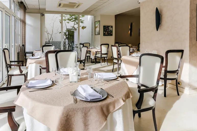 Restaurant avec tables dressé, chaises blanches, résidence Le Cap à Colombes
