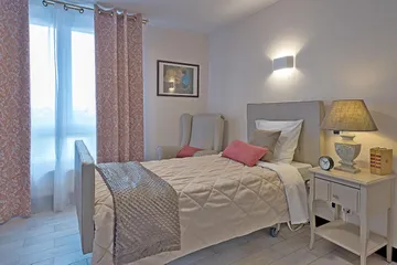 Chambre avec lit simple, table de nuit, fenêtre à la résidence Esterel à Colombes