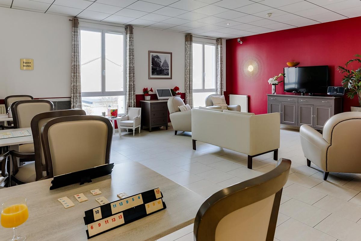 Salon avec espace télé et jeux de société à la Résidence le Cap à Bois-Colombes