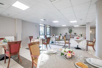 salle de restauration blanche et grise avec tables décorées maison de retraite st cloud résidence longchamp
