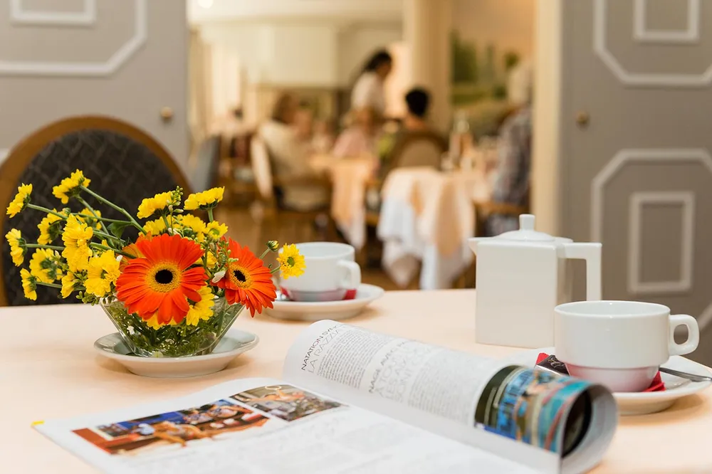 Zoom table avec fleur frais journal ouvert et thé et café, fond floue,