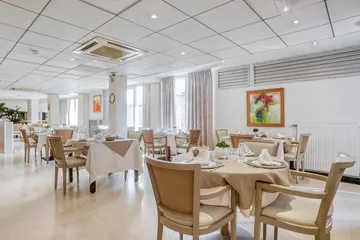 Restaurant élégant avec tables soigneusement dressé, chaises et nappes beiges, Résidence à Asnières