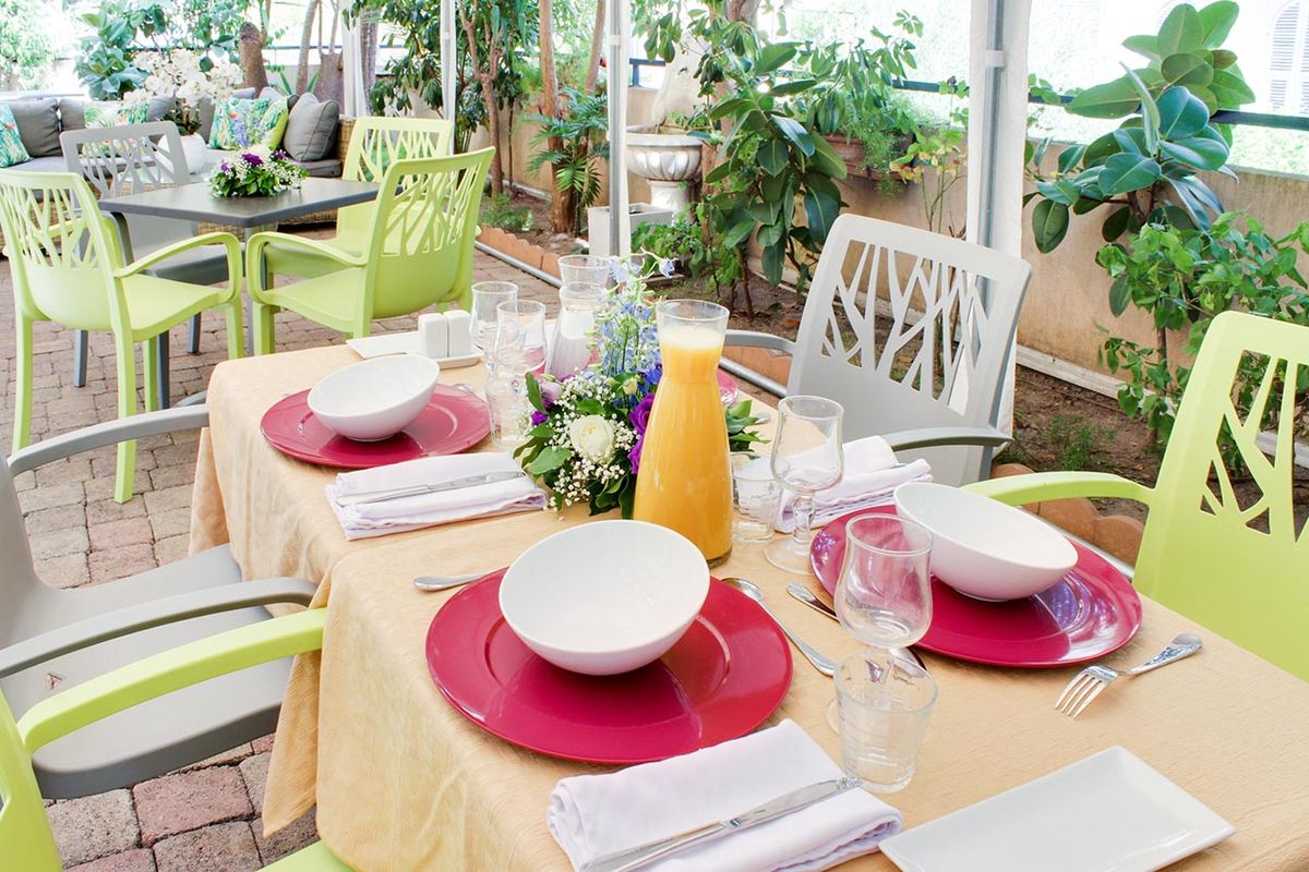 déjeuner en plein air avec table dressé, fleur et chaises résidence bleu soleil nice