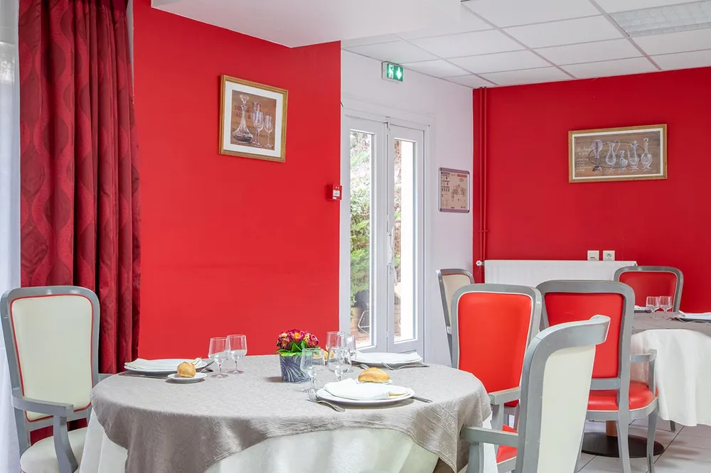 Salle de restauration rouge avec tables grises en maison d retraite à Trie Château, Les Jardins de la Tour
