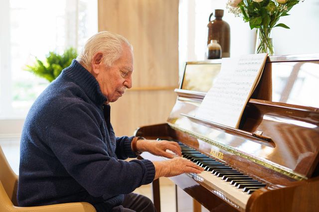 Piano droit pleyel F124 bois personne agé joue Les Jardins d'Epinay