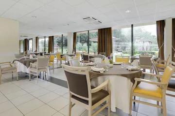 Salle de restauration blanc et marron, tables rondes en ehpad à Crouy-en-Thelle, Résidence Les Cèdres