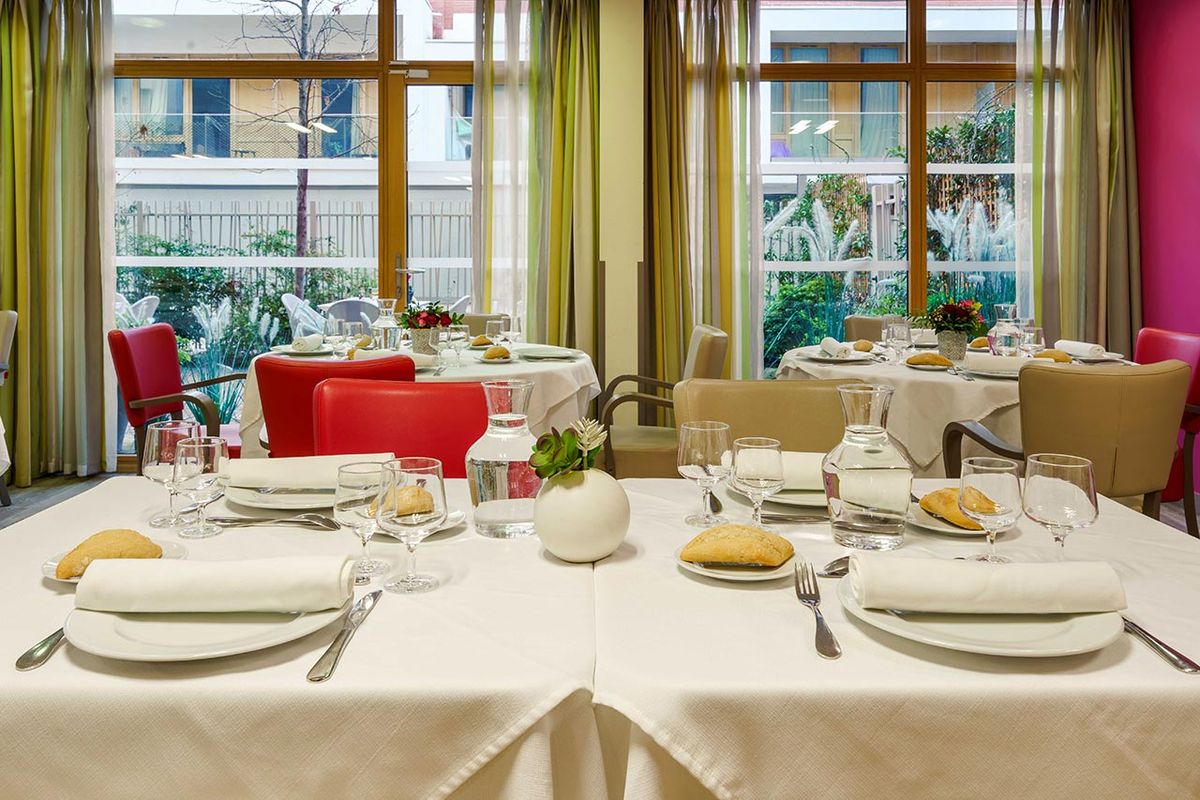 tables dréssées vue dégagée avec baie vitrée lumineuse et chaleureuse Résidence Ornano à Paris