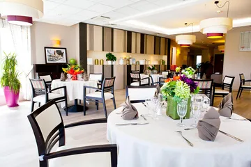 Salle de restaurant moderne avec tables rondes décorées, design bois multicolore rétro