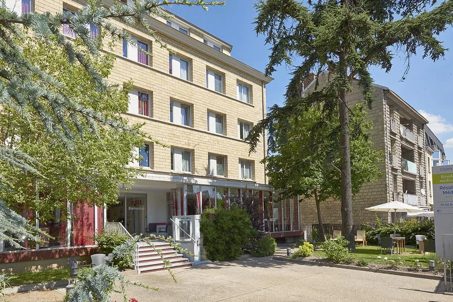 Vue extérieur batiment brique beige maison retraite Médicis à Argenteuil avec arbres et nature