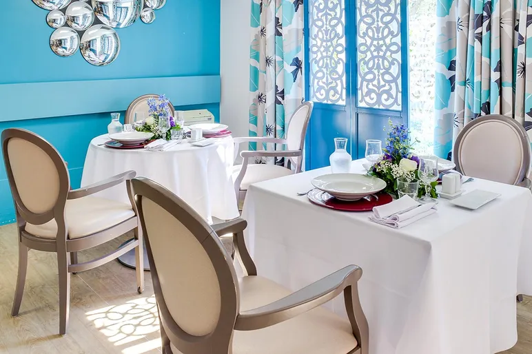 salle de restaurant avec mur bleu, rideaux fleuris, tables dressée, résidence bleu soleil à NIce