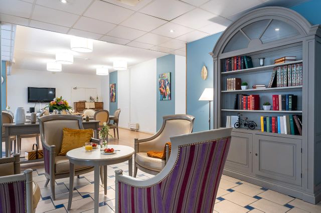 Salon et librairie avec fauteuils rayures, maison de retraite seniors Compiegne, Résidence Tiers Temps