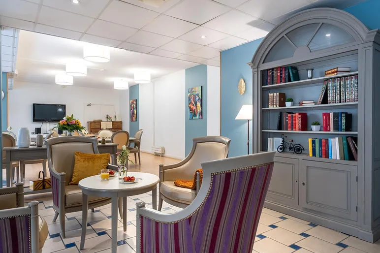Salon et librairie avec fauteuils rayures, maison de retraite seniors Compiegne, Résidence Tiers Temps