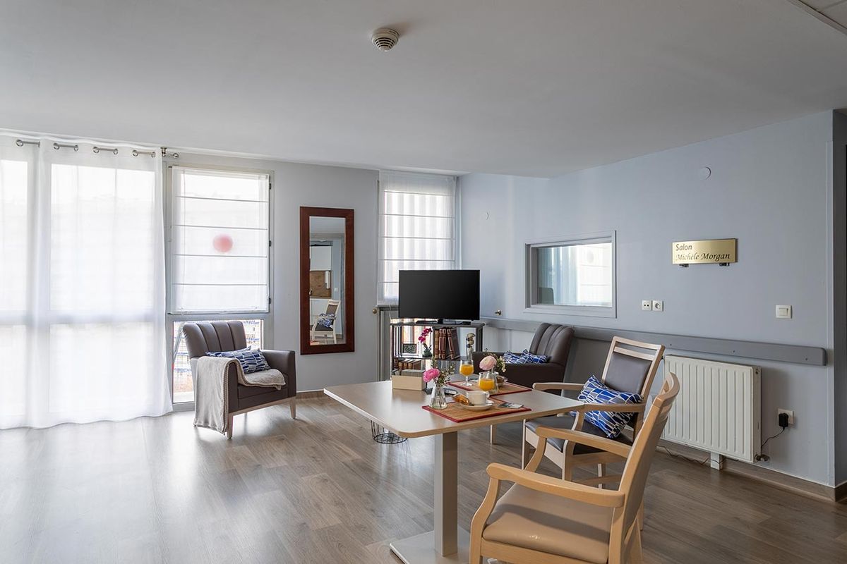 Salon avec tables, chaises et télévision, Résidence Médicis