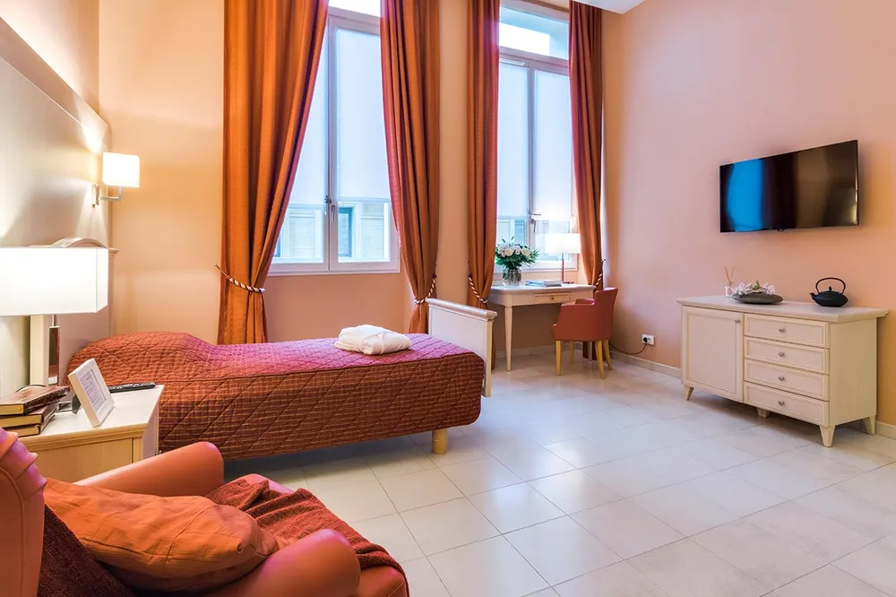 Chambre rose et rouge lumineuse avec télévision EHPAD Résidence du Palais à Marseille