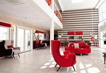 Lobby moderne soft lounge rouge et gris, lumineux en maison de retraite à Le Rove, La Carrairade