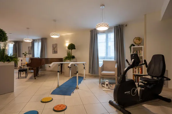 Salle de rééducation avec équipements sportifs et piano, ehpad à clichy