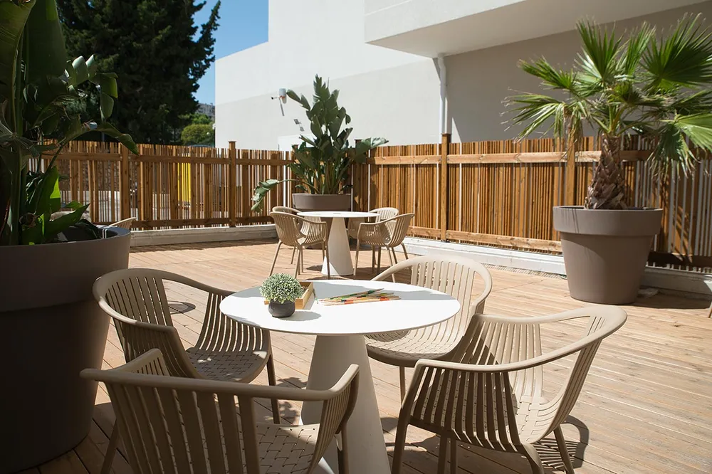 Terrasse de jardin et tables sur deck pour repas extérieur villa résidence ehpad Sainte-Marthe à Marseille