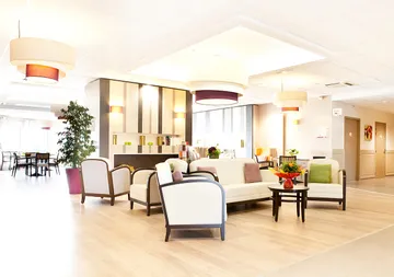 Salle commune maison retraite Les Jardins de Creney  décoration rétro chic avec canapé blanc