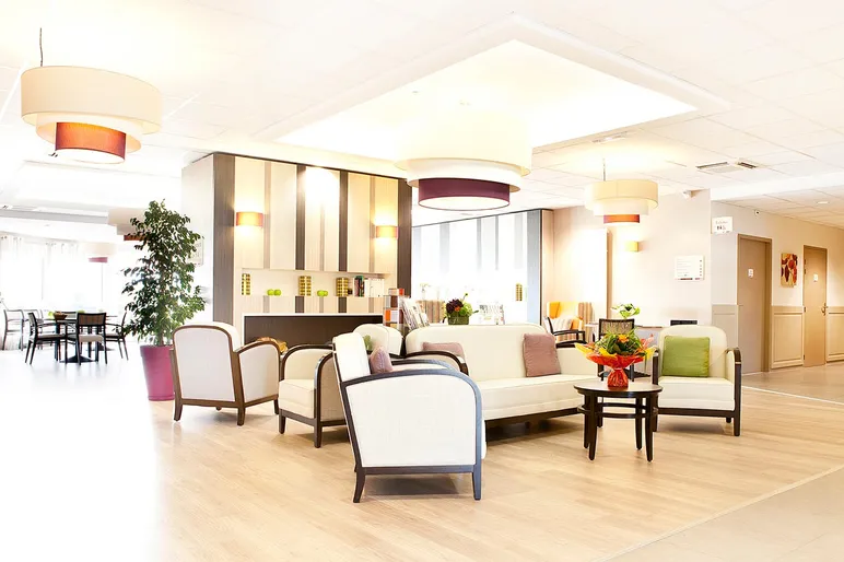 Salle commune maison retraite Les Jardins de Creney  décoration rétro chic avec canapé blanc