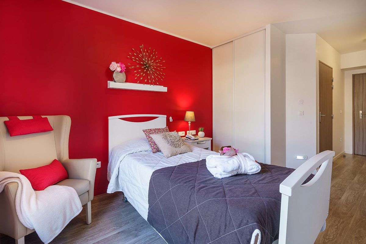 Chambre Résidence Ornano à Paris chaleureuse avec mur rouge et blanc décorée