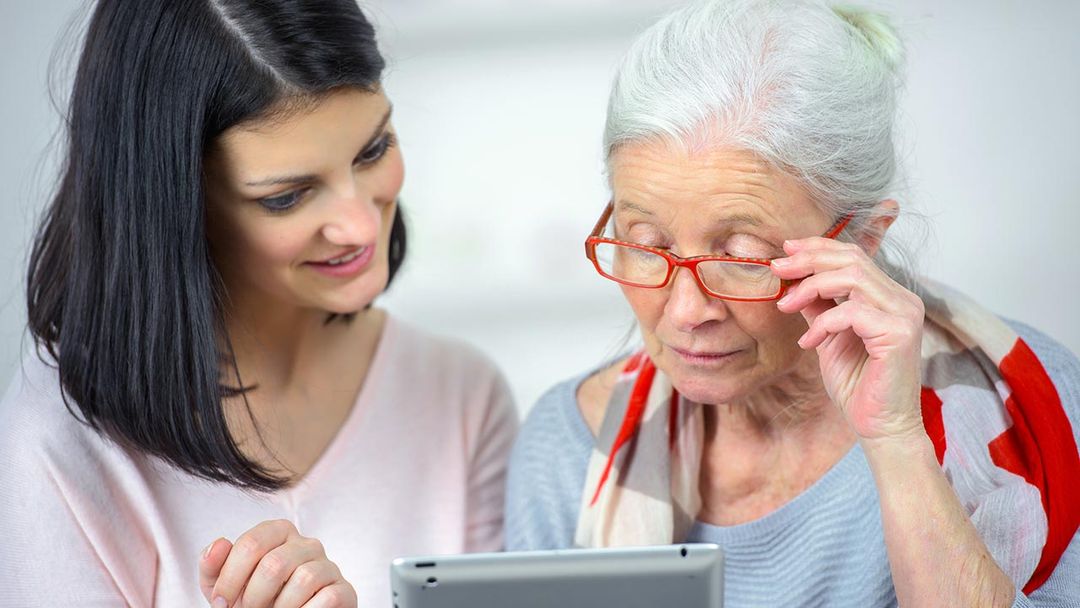 une jeune femme et une femme âgées regardent une tablette