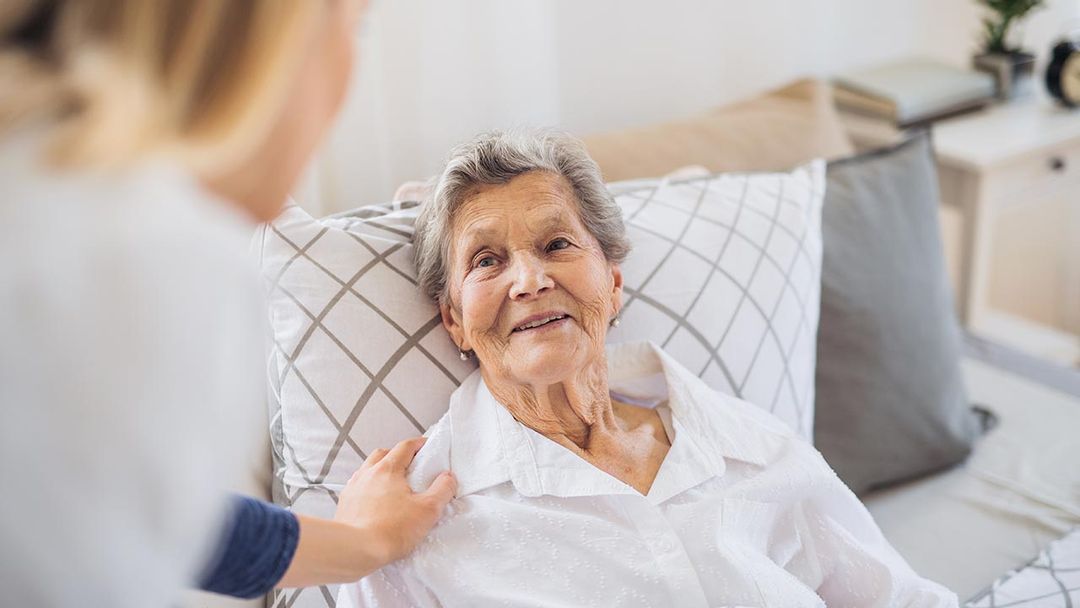 auxiliaire de vie avec une personne âgée alitée