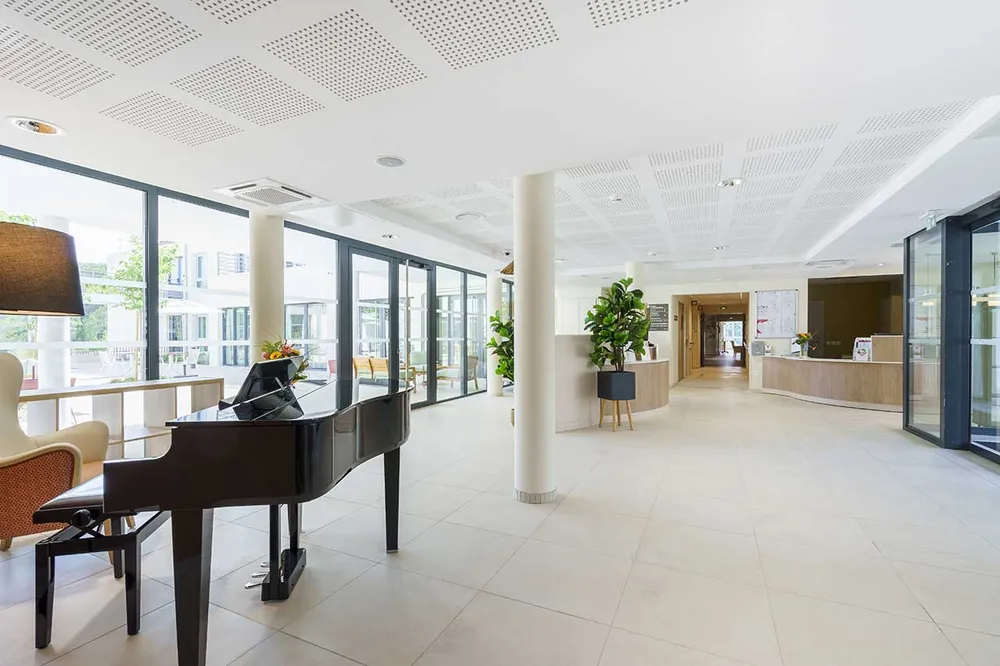 Salle de récetption acceuil, moderne, mur blanc et piano queue noir, ehpad à Allauch, Ecrin des Collines
