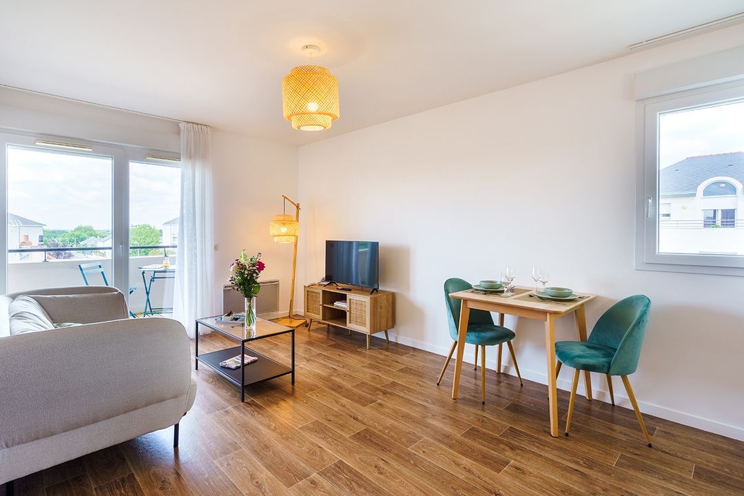 appartement moderne avec télé, petite table, chaises et canapé résidence les templitudes d'avrille