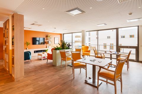 Salon de détente convivial et lumineux avec canapé, TV et jeux, EHPAD à Vitry