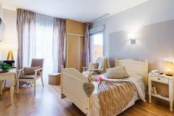 Chambre confortable avec lit simple, décoration et éclairage tamisé ehpad le cannet