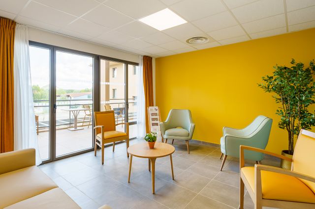 Salon lumineux avec fauteuils confortables dans l’EHPAD La Bastide du Grand Vallat