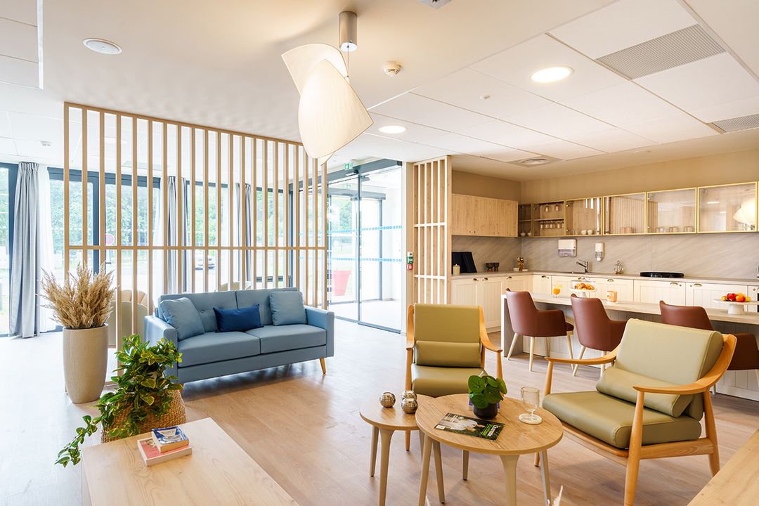 Espace club avec canapé confortable et coin cuisine, résidence seniors pinede de suzac