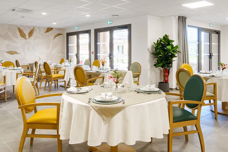 Tables dressées dans le restaurant lumineux de la résidence médicalisée au Bouc Bel-Air