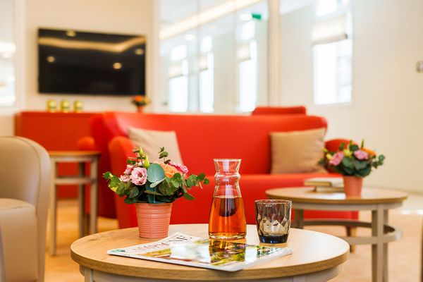 Décoration intérieur avec des fleurs et un récipient d'eau à la Résidence Pavillon Charlotte