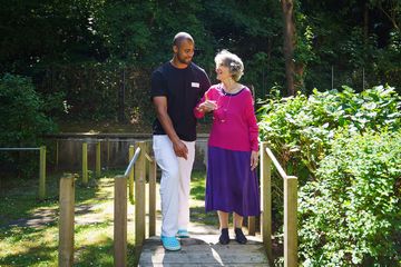 personnel aide une femme âgée à marcher dans la résidence simon vouet