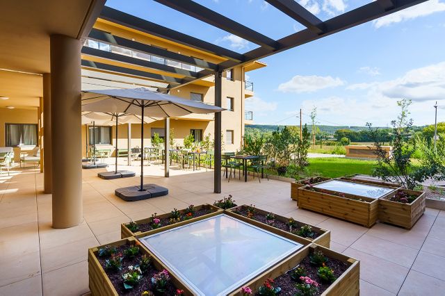 Terrasse aménagée avec jardinières dans l’EHPAD La Bastide du Grand Vallat
