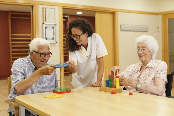 Cuidadora y ancianos en un taller terapéutico