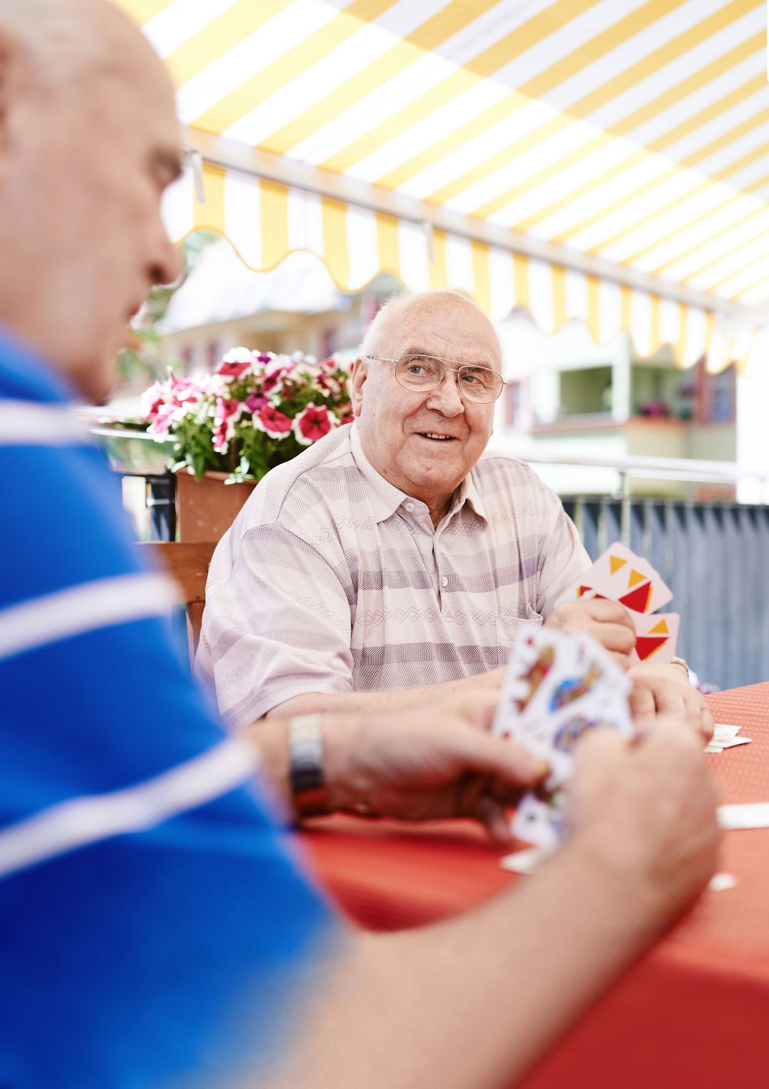 zwei Senioren spielen Karten in einer advita Pflegeeinrichtung