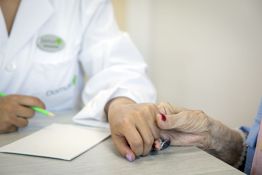 Trabajadora dándole la mano a residente