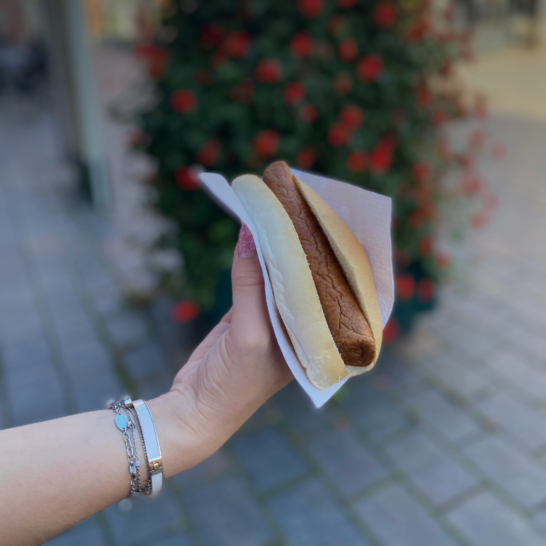 Broodje kipfrikandel met bloemen op de achtergrond
