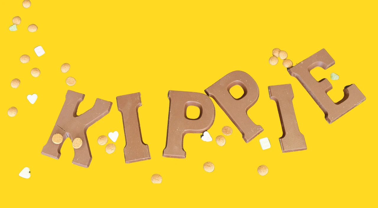 Chocolade letters met "KIPPIE" op een gele achtergrond met wat strooigoed