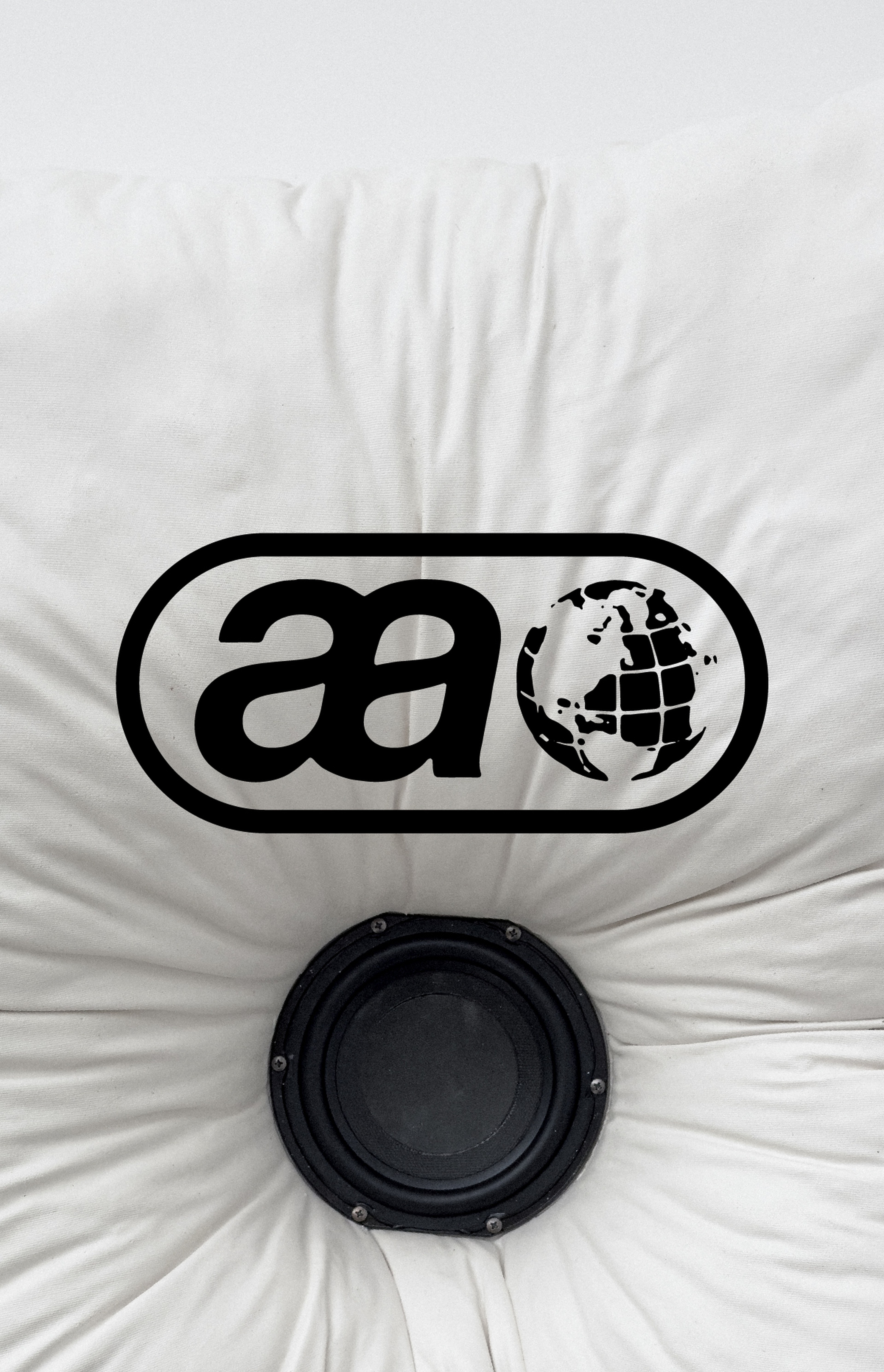 Black globe and "aa" logo on a white surface, centered above a round black speaker embedded in the fabric.