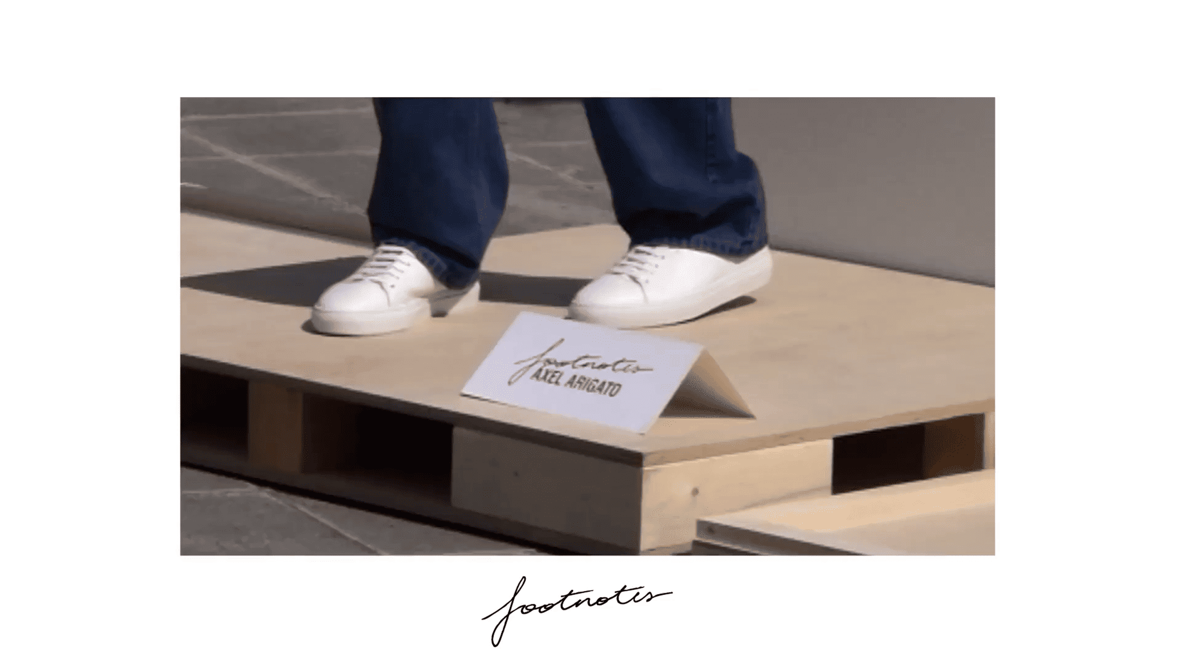 Person wearing white sneakers stands on a wooden platform with a sign labeled "Footnotes."