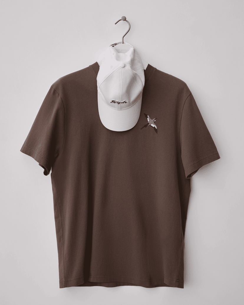Brown T-shirt with a star-shaped brooch and a white cap hanging on a hook.