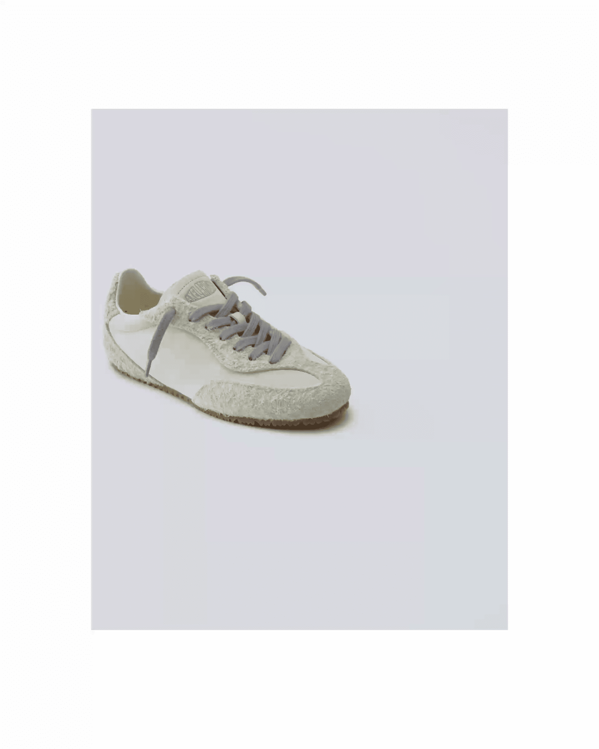 Light gray sneaker on a white background, featuring a textured sole and matching laces.