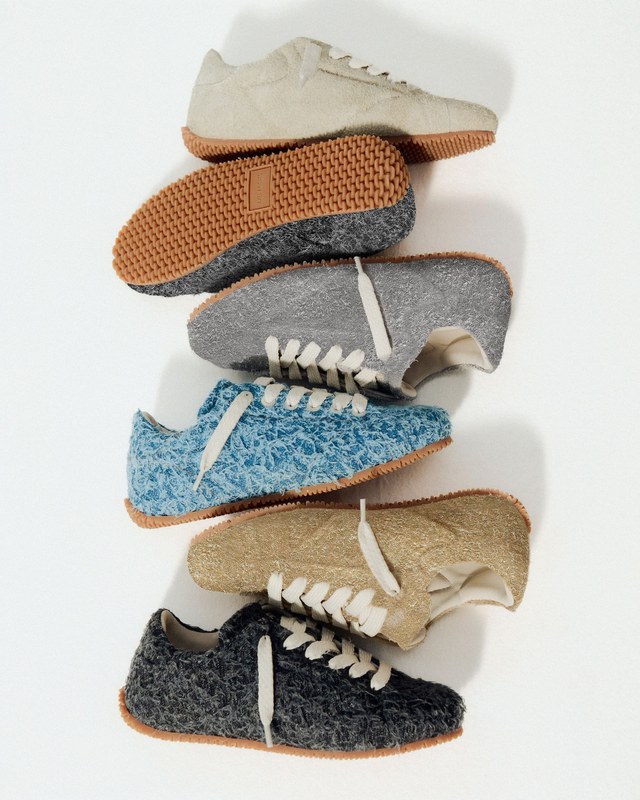 Five textured sneakers in beige, gray, blue, and black stacked vertically, showcasing their unique fabric and gum soles against a white background.