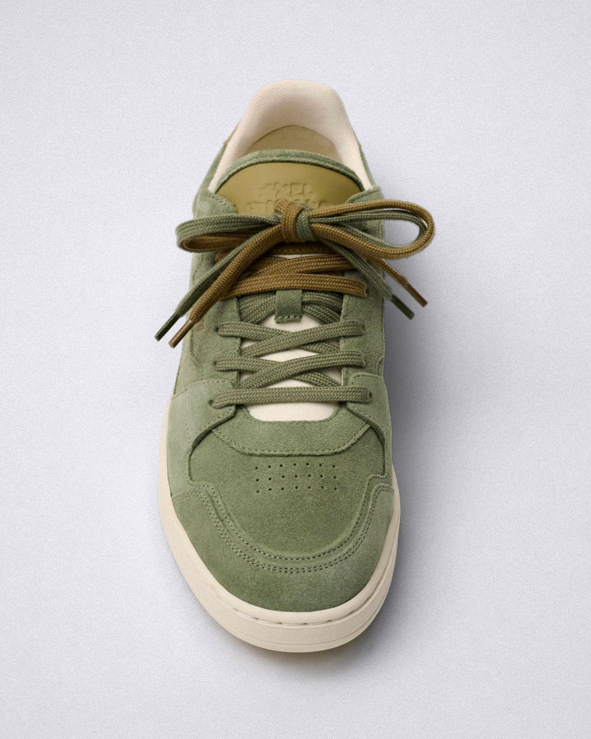 Olive green sneaker with tan accents and thick laces, shown from above on a gray background.