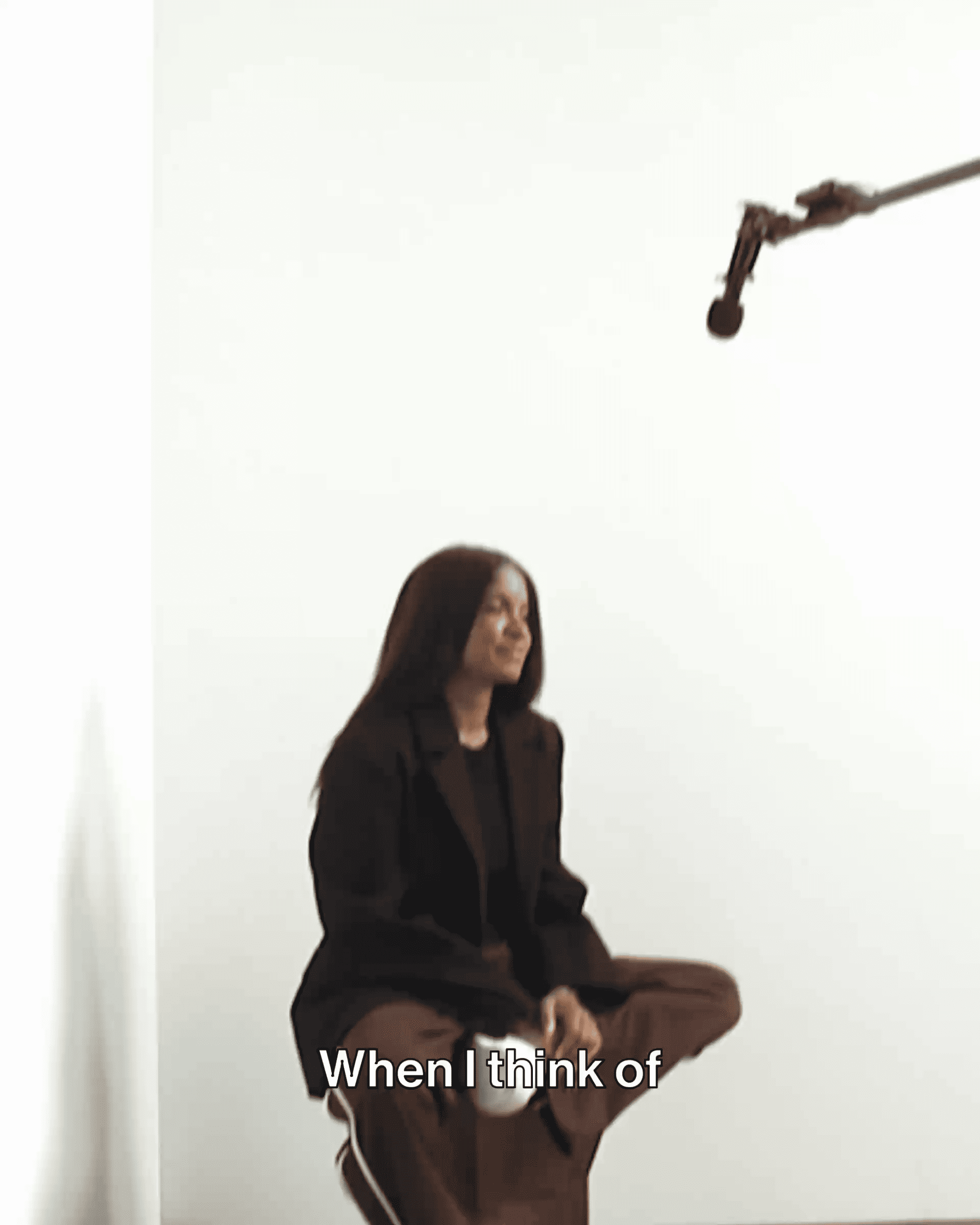 A person with long hair sits in a studio with a microphone overhead. The text reads, "When I think of."